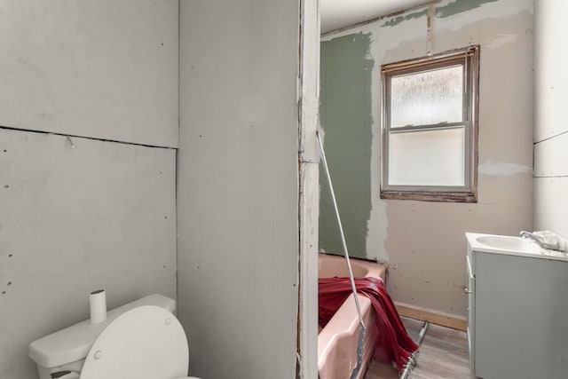 bathroom featuring a bathtub, a shower, toilet, vanity, and wood finished floors