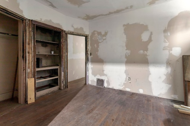 empty room with visible vents and hardwood / wood-style flooring