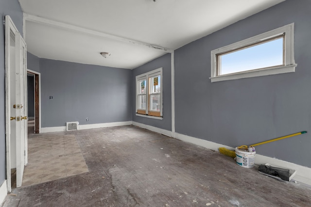 spare room with a healthy amount of sunlight, visible vents, and baseboards