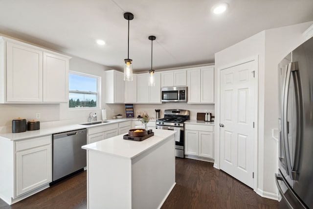 kitchen featuring dark wood finished floors, white cabinetry, stainless steel appliances, and a sink