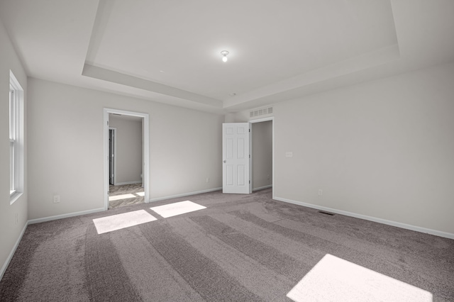 4278 Oak St, Grand Blanc, MI 48439 - unfurnished bedroom with baseboards, carpet, a tray ceiling, and visible vents