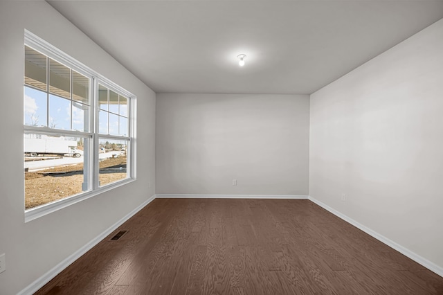 4278 Oak St, Grand Blanc, MI 48439 - spare room featuring baseboards, visible vents, and dark wood-type flooring
