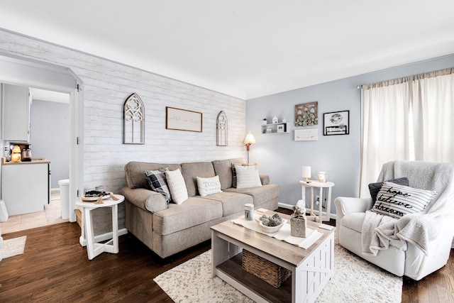 living room featuring an accent wall and wood finished floors