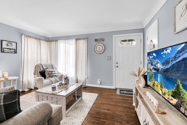 living area with dark wood-style flooring and baseboards