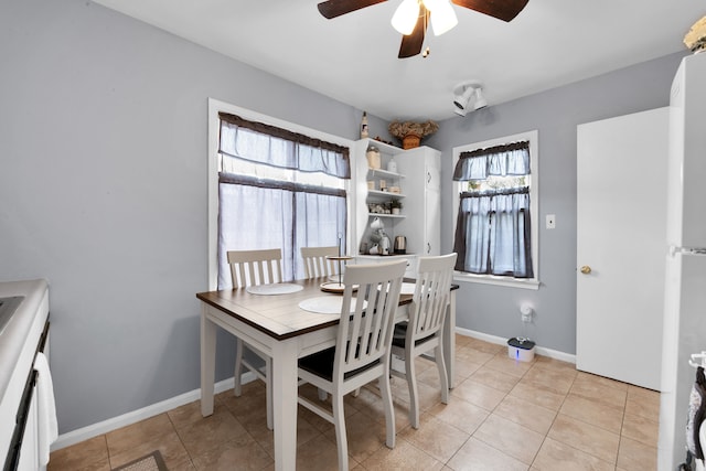 dining area featuring ceiling fan, baseboards, and light tile patterned flooring