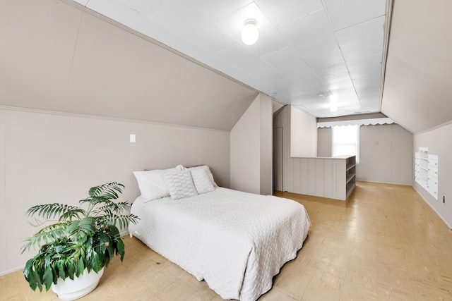 bedroom featuring lofted ceiling and light floors