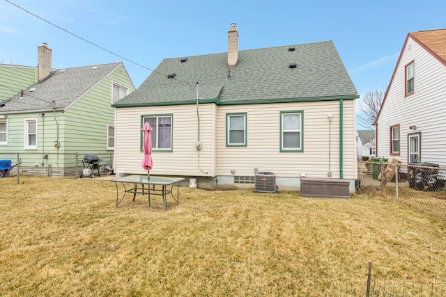 rear view of house featuring a chimney, central air condition unit, a shingled roof, a lawn, and a fenced backyard