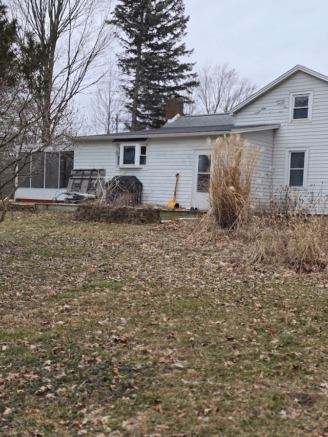 rear view of property featuring a chimney