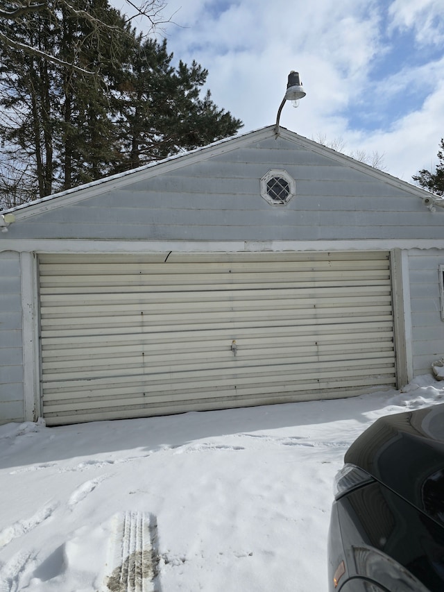 snow covered garage featuring a detached garage