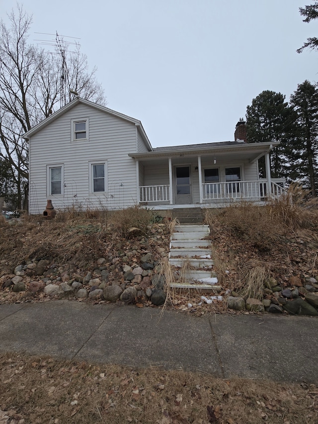 view of front of property featuring covered porch and a chimney