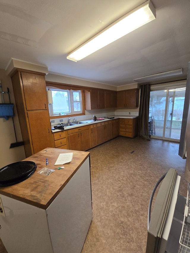 kitchen with wooden counters, brown cabinetry, and a sink