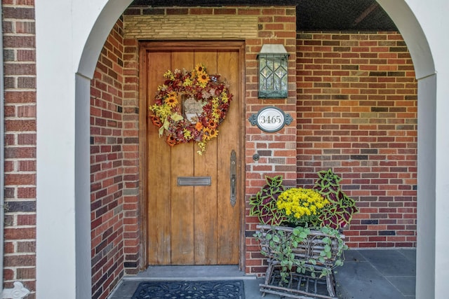 entrance to property featuring brick siding