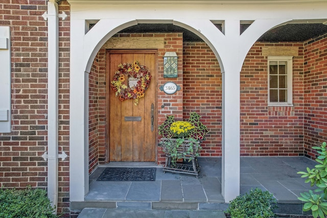 property entrance featuring brick siding