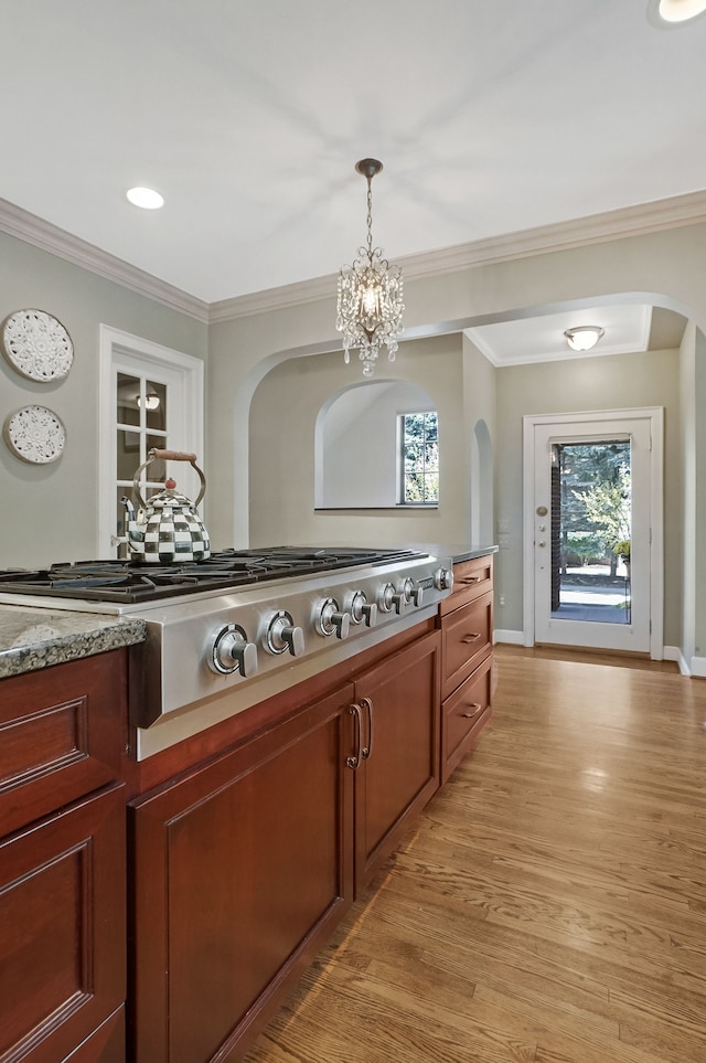 kitchen with light wood-type flooring, a wealth of natural light, and ornamental molding