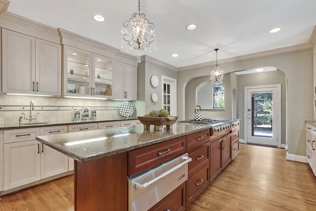 kitchen featuring a sink, tasteful backsplash, stainless steel gas cooktop, and a warming drawer