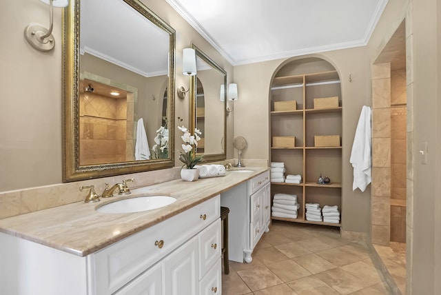 bathroom featuring crown molding, double vanity, a sink, a tile shower, and tile patterned flooring