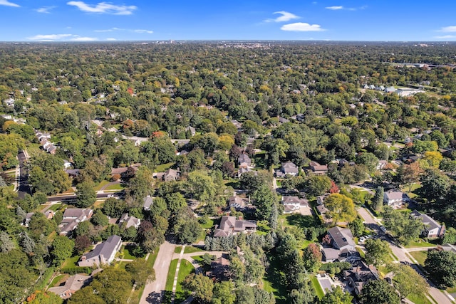 drone / aerial view featuring a residential view and a view of trees