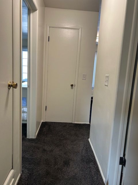 hallway with carpet and baseboards