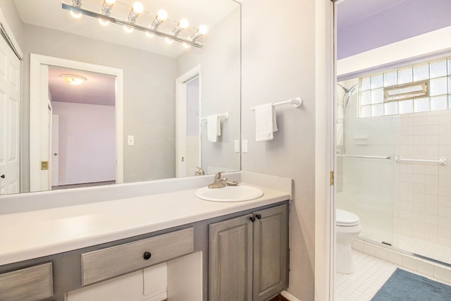 full bathroom featuring a stall shower, vanity, toilet, and tile patterned floors