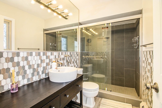 full bath featuring a stall shower, vanity, toilet, and decorative backsplash