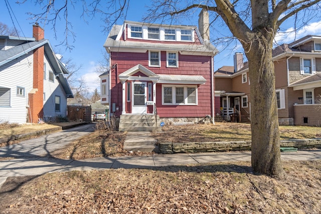 traditional style home featuring entry steps and a chimney