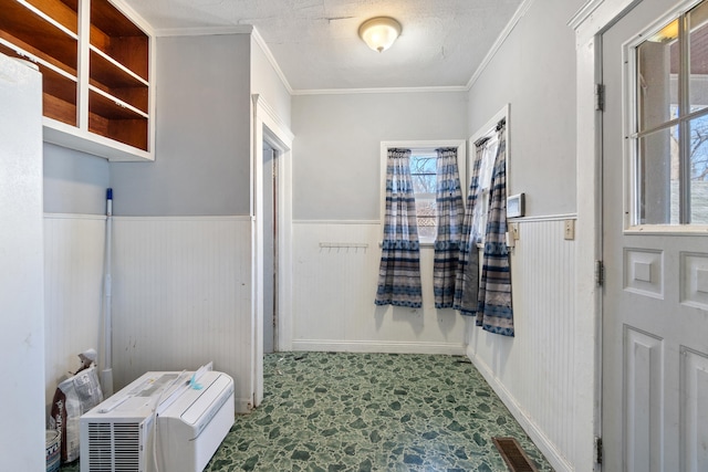 bathroom with wainscoting, crown molding, visible vents, and a textured ceiling