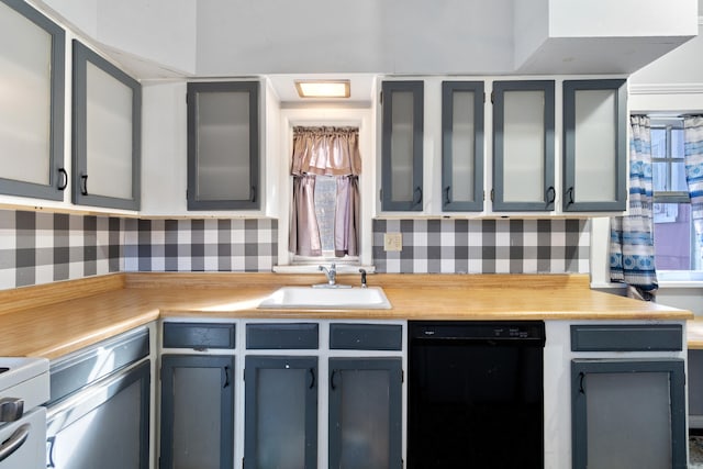 kitchen featuring gray cabinets, black dishwasher, light countertops, and a sink