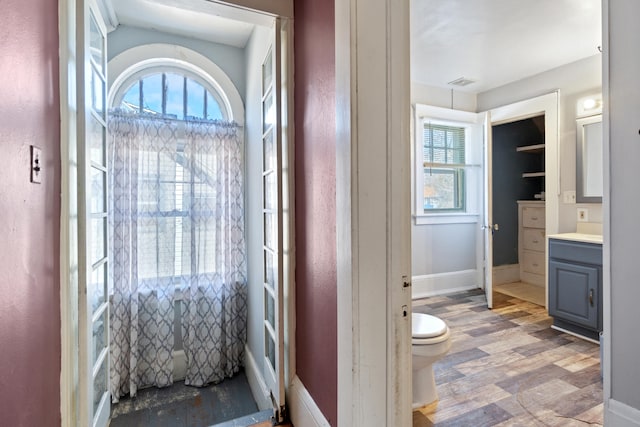 bathroom featuring toilet, visible vents, a wealth of natural light, and vanity