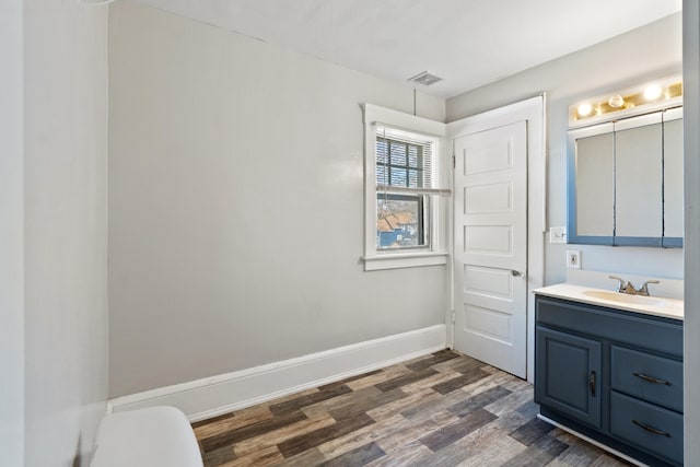 bathroom with baseboards, visible vents, wood finished floors, and vanity