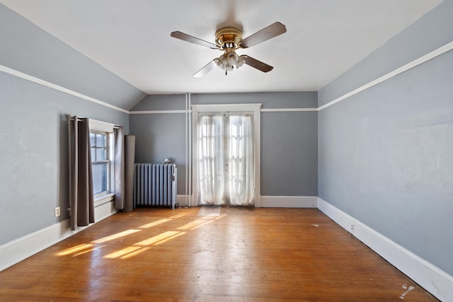 spare room featuring radiator, a wealth of natural light, and wood finished floors