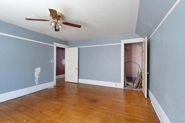 interior space with ceiling fan, baseboards, and hardwood / wood-style floors