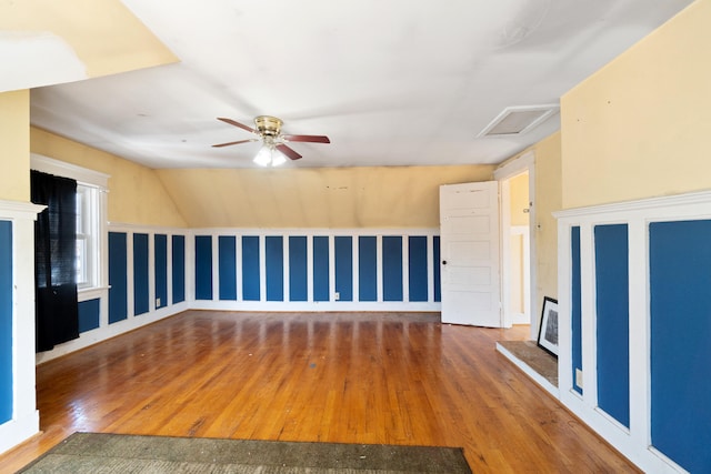 unfurnished living room with wood finished floors and attic access