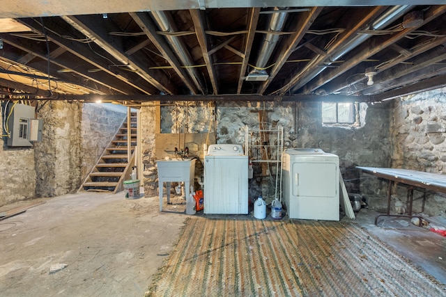 basement with stairs, washer and clothes dryer, and a sink