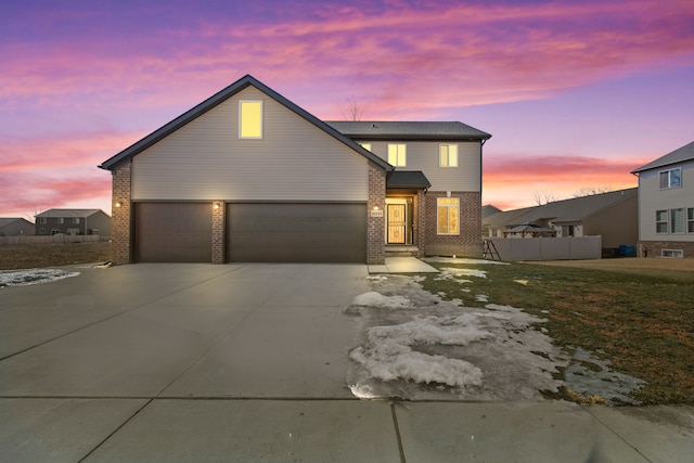 view of front of property featuring an attached garage, concrete driveway, and brick siding