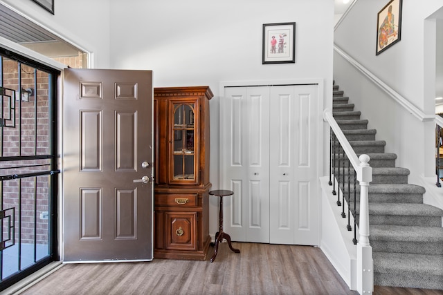 foyer entrance with stairs and wood finished floors