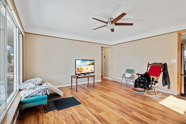 sitting room with visible vents, crown molding, baseboards, and wood finished floors