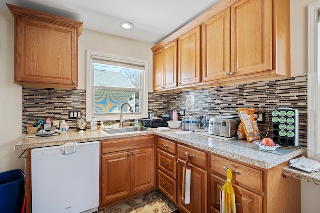 kitchen with white dishwasher, light countertops, and a sink