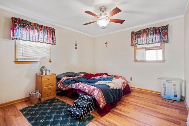 bedroom with baseboards, wood finished floors, a ceiling fan, and crown molding