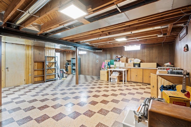 below grade area with wood walls and tile patterned floors