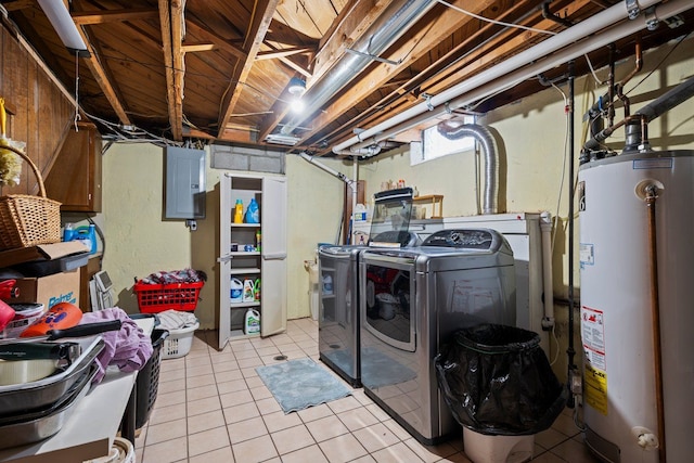 clothes washing area with gas water heater, washing machine and dryer, light tile patterned flooring, laundry area, and electric panel