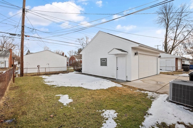 detached garage with cooling unit, fence, and driveway