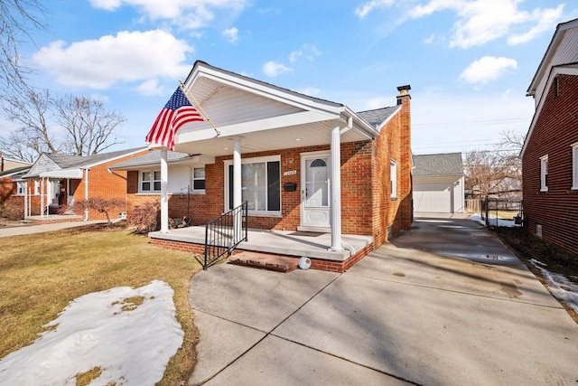 bungalow featuring brick siding, a chimney, a porch, an outdoor structure, and a front lawn