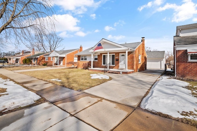 bungalow with a chimney, a front lawn, an outdoor structure, and brick siding