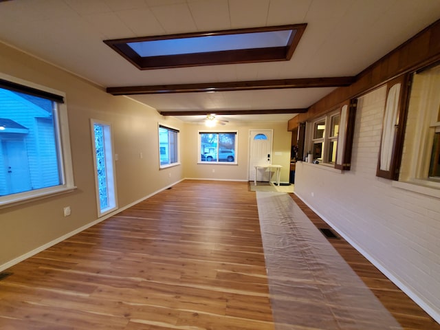 spare room featuring visible vents, beamed ceiling, and wood finished floors