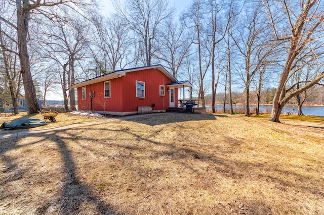 view of side of property with a water view and a lawn