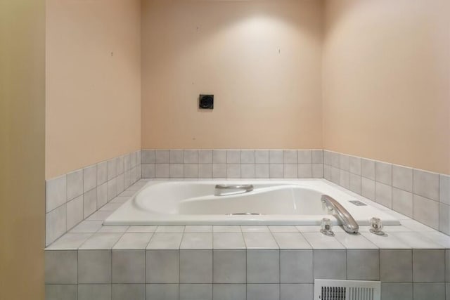 bathroom with a bath and visible vents