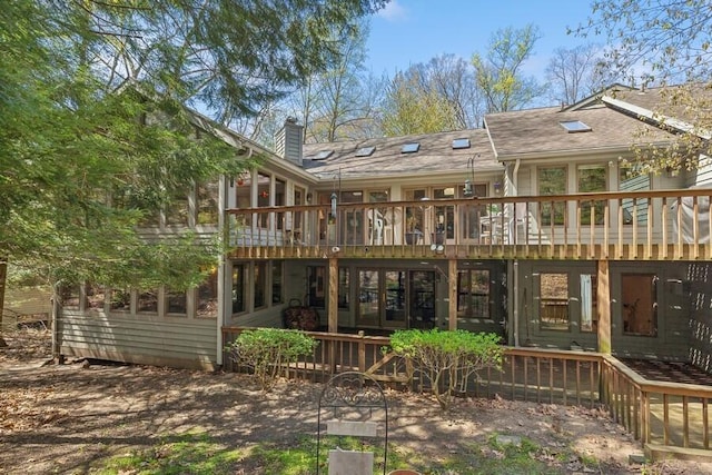 rear view of house with a chimney and a wooden deck