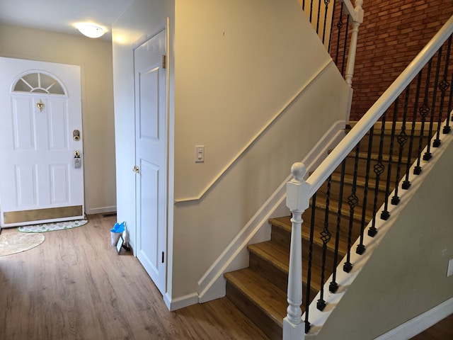 staircase with baseboards and wood finished floors