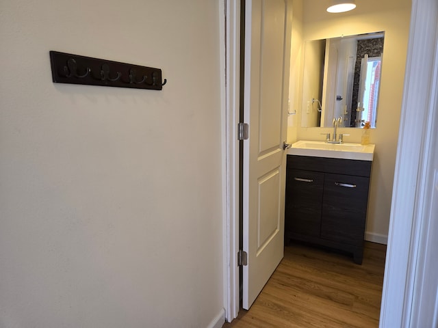 bathroom with vanity, baseboards, and wood finished floors