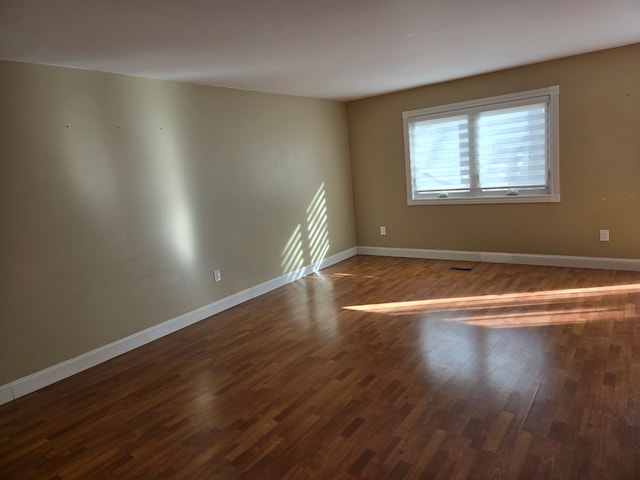 unfurnished room featuring wood finished floors and baseboards